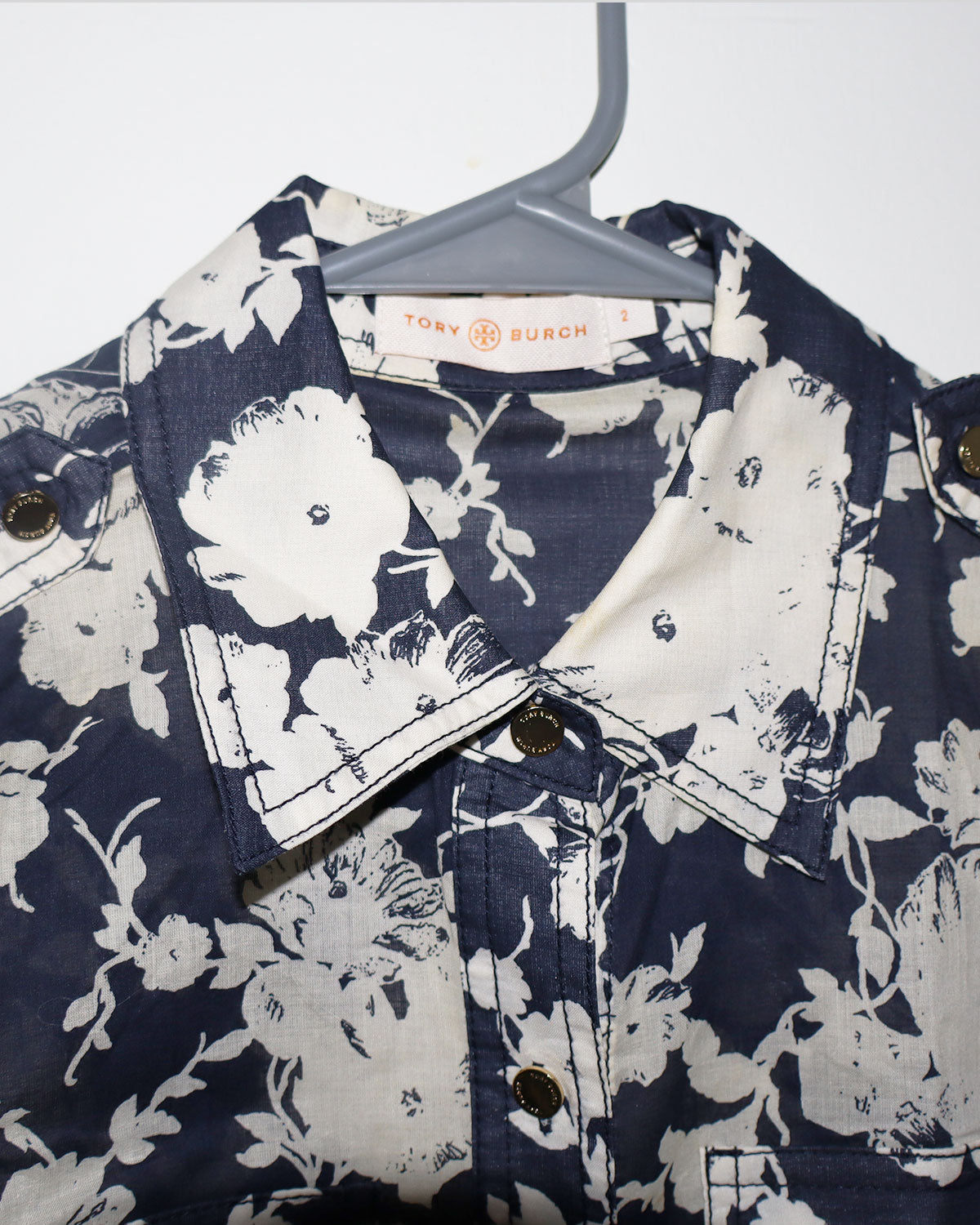 Navy floral shirt on a hanger with 'Tory Burch' label.