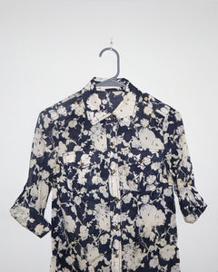 Floral patterned shirt on a hanger against a white background